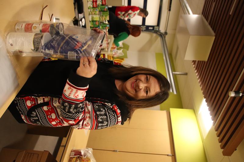 Woman placing boxes and cans fo food in bag.